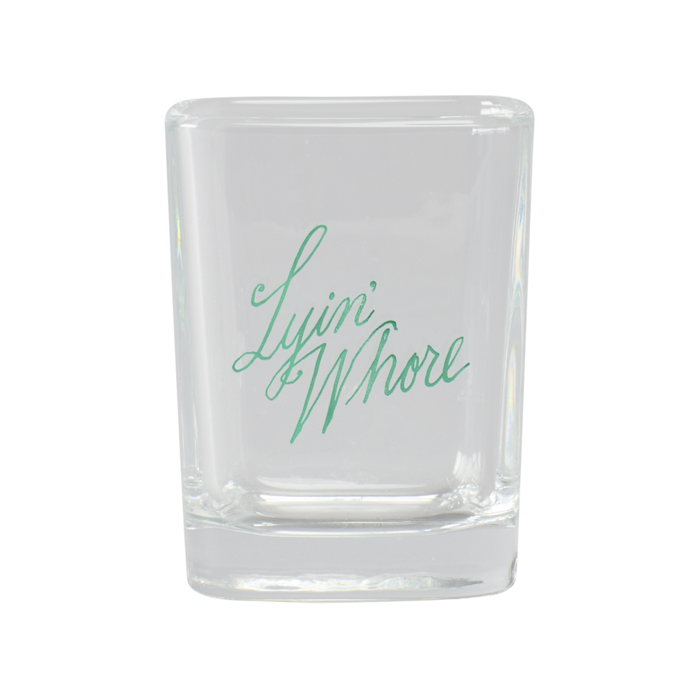 Clear glass with 'Lying Whore' text in green on a white background