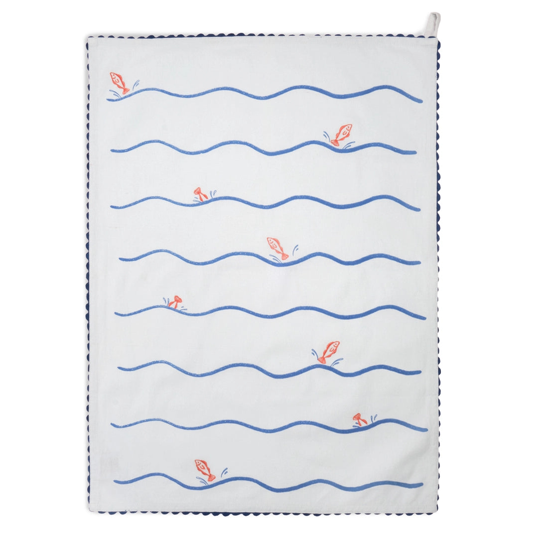 Pale blue tea towel folded lengthwise and hanging vertically, with bold blue wavy horizontal lines and a small orange fish illustration, finished with dark blue scalloped trim.