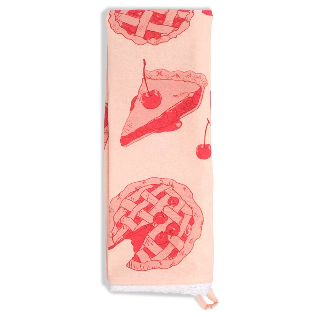 Pale pink tea towel folded lengthwise and hanging vertically, decorated with red illustrations of cherry pie slices, lattice-top pies, and cherries, with white lace trim at the bottom.
