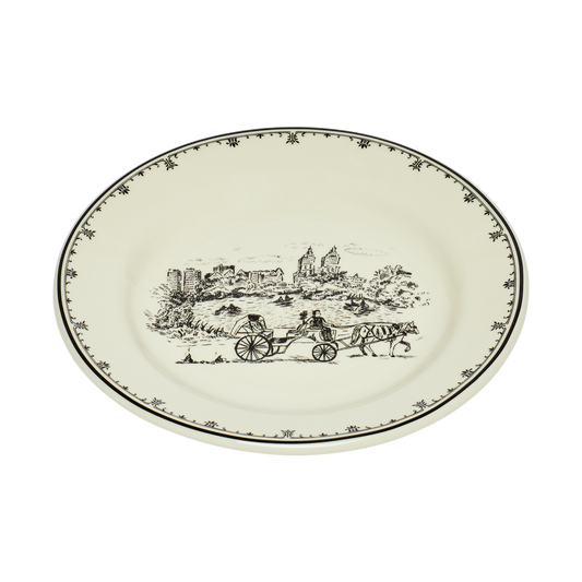 Round ceramic plate with black decorative design on a white background