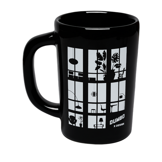Black mug with white design and 'Dumbo' branding on a white background