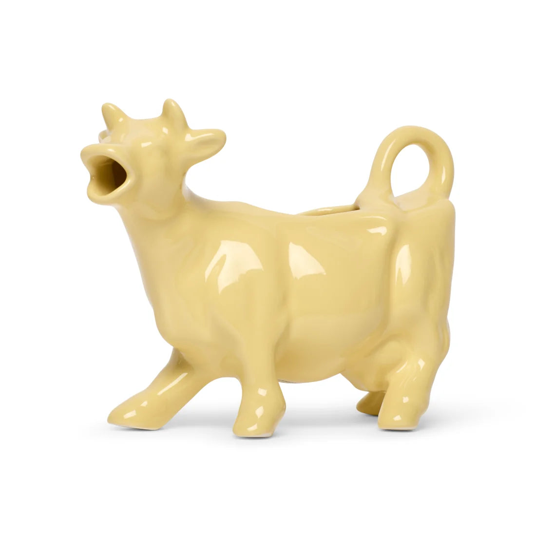 Butter yellow ceramic cow-shaped creamer with an open mouth spout and tail handle, side view