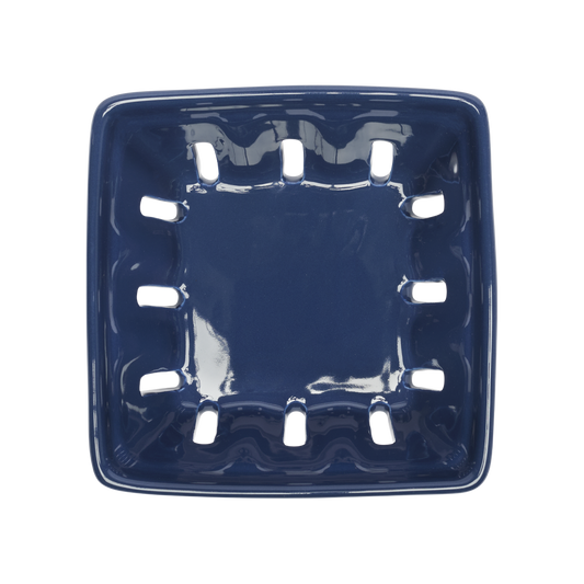 Blue ceramic soap dish with decorative holes on a white background