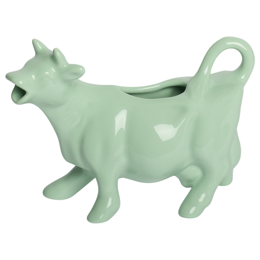 Mint green ceramic cow-shaped planter on a white background