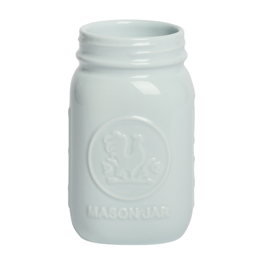 White mason jar with embossed design on a white background