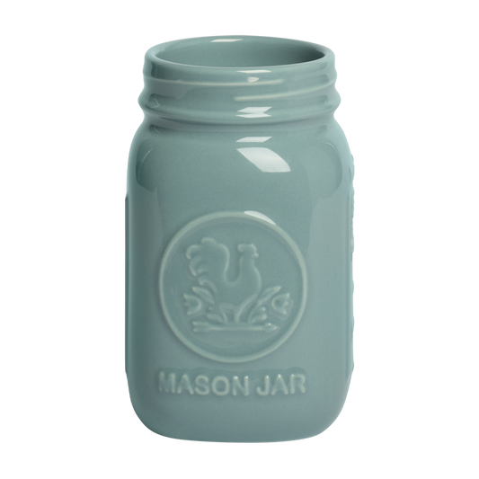 Light blue mason jar with embossed design on a white background