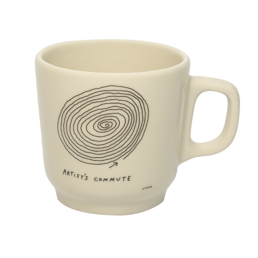 A white ceramic mug with a hand-drawn spiral and the text 'ARTIST'S COMMUTE' on the side.