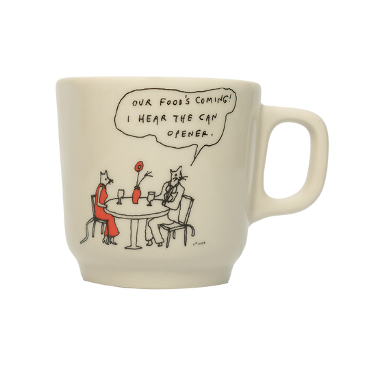 A white ceramic mug with a hand-drawn cartoon illustration of a character saying 'Our food's coming! I hear the can opener' at a table with a cat.