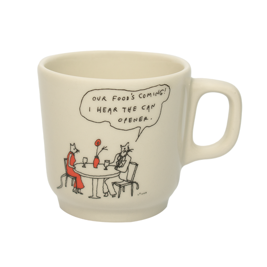 A white ceramic mug with a hand-drawn cartoon illustration of a character saying 'Our food's coming! I hear the can opener' at a table with a cat.