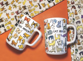 Dog Person and Cat Person ceramic mugs shown side by side, featuring bold black typography on classic white diner-style mugs.