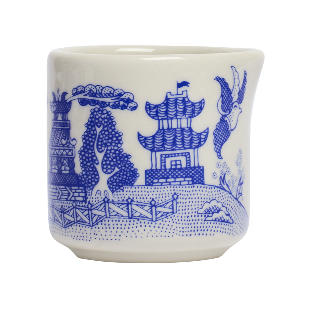 White ceramic cup with blue decorative patterns on a white background