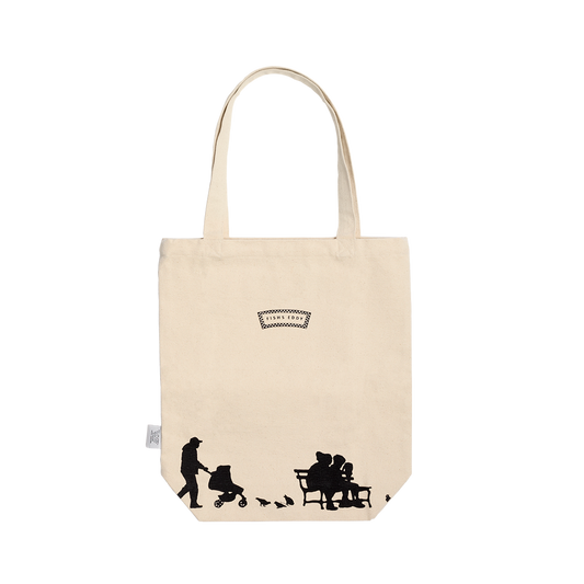 Beige tote bag with black silhouettes and a visible brand logo on a white background