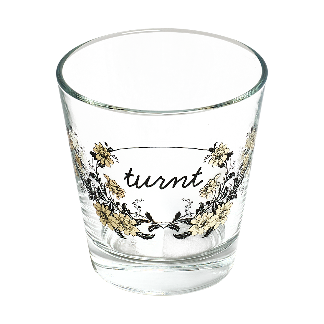 Clear glass tumbler with floral design and 'turnt' text on a white background