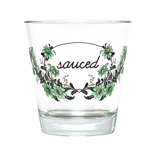 Clear glass with floral design and 'sauced' text on a white background