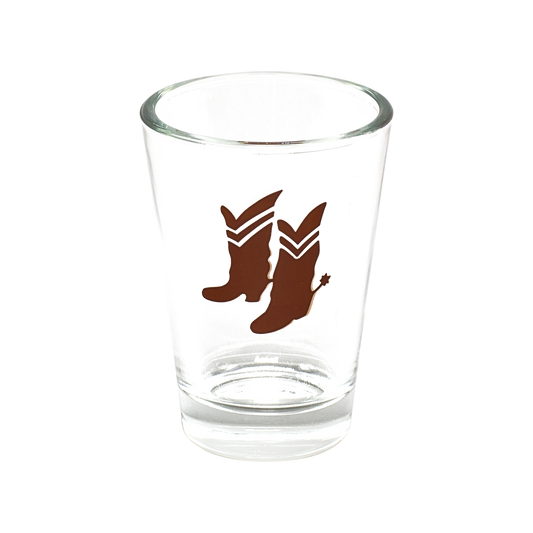 Clear glass shot glass with brown cowboy boot design on a white background
