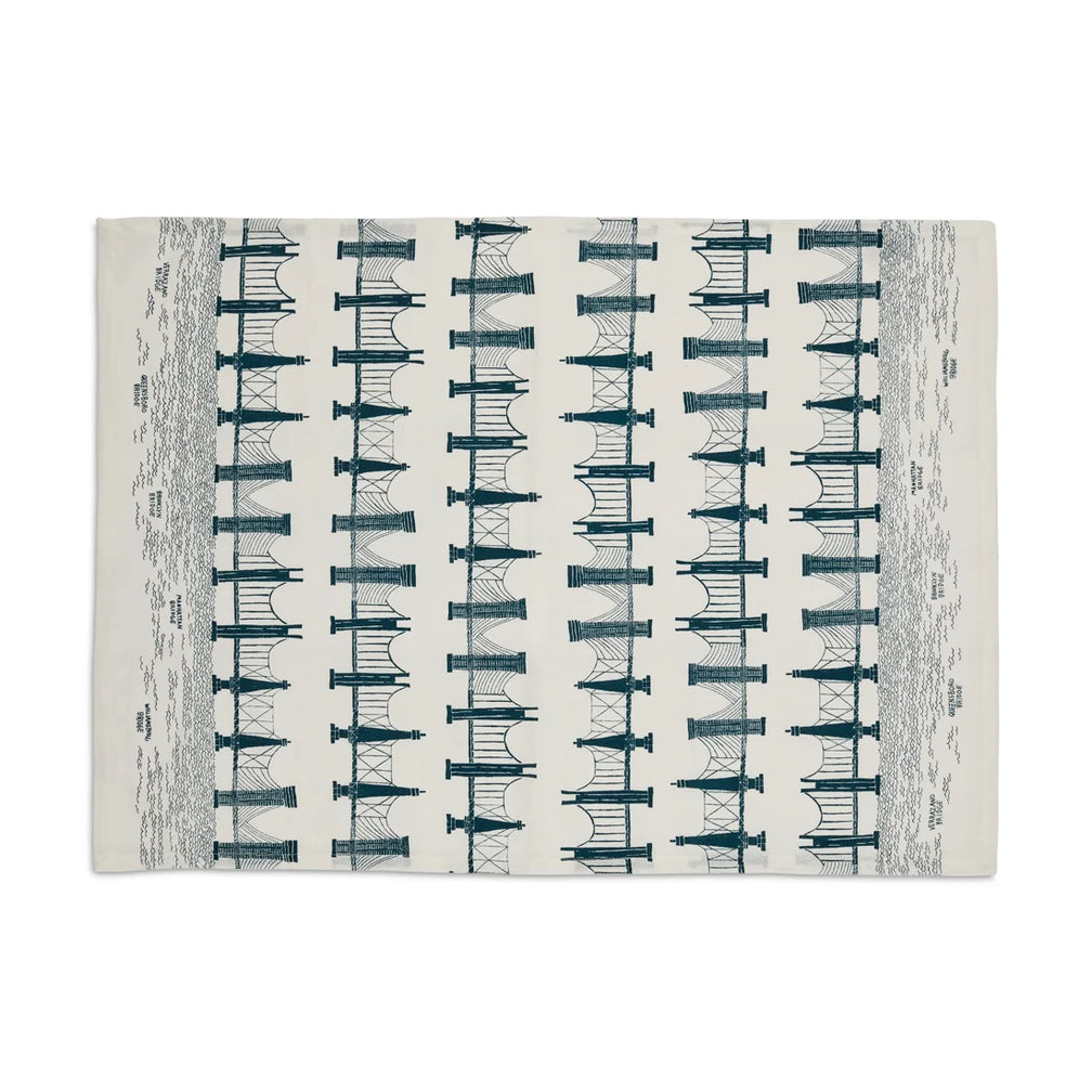 Cream tea towel laid flat printed with repeating teal bridge and tunnel illustrations