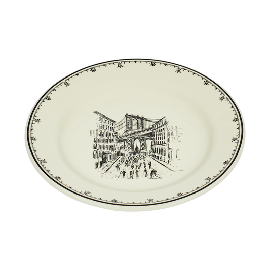 Round ceramic plate with a black and white illustration of a city scene on a white background