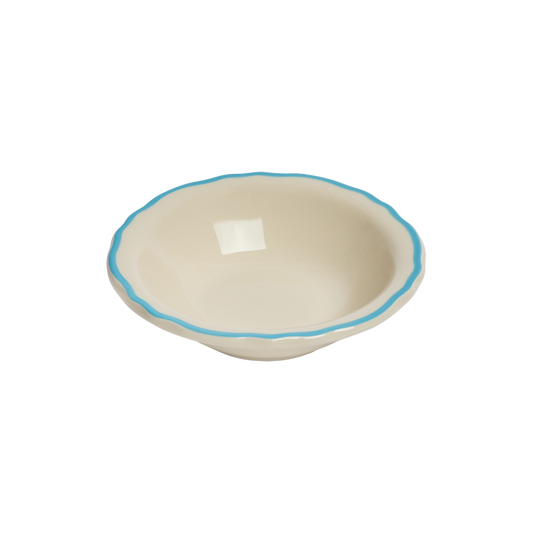 Beige ceramic bowl with blue rim on a white background