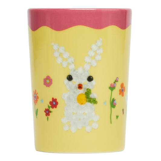 Decorative cup with a bunny design on a yellow background
