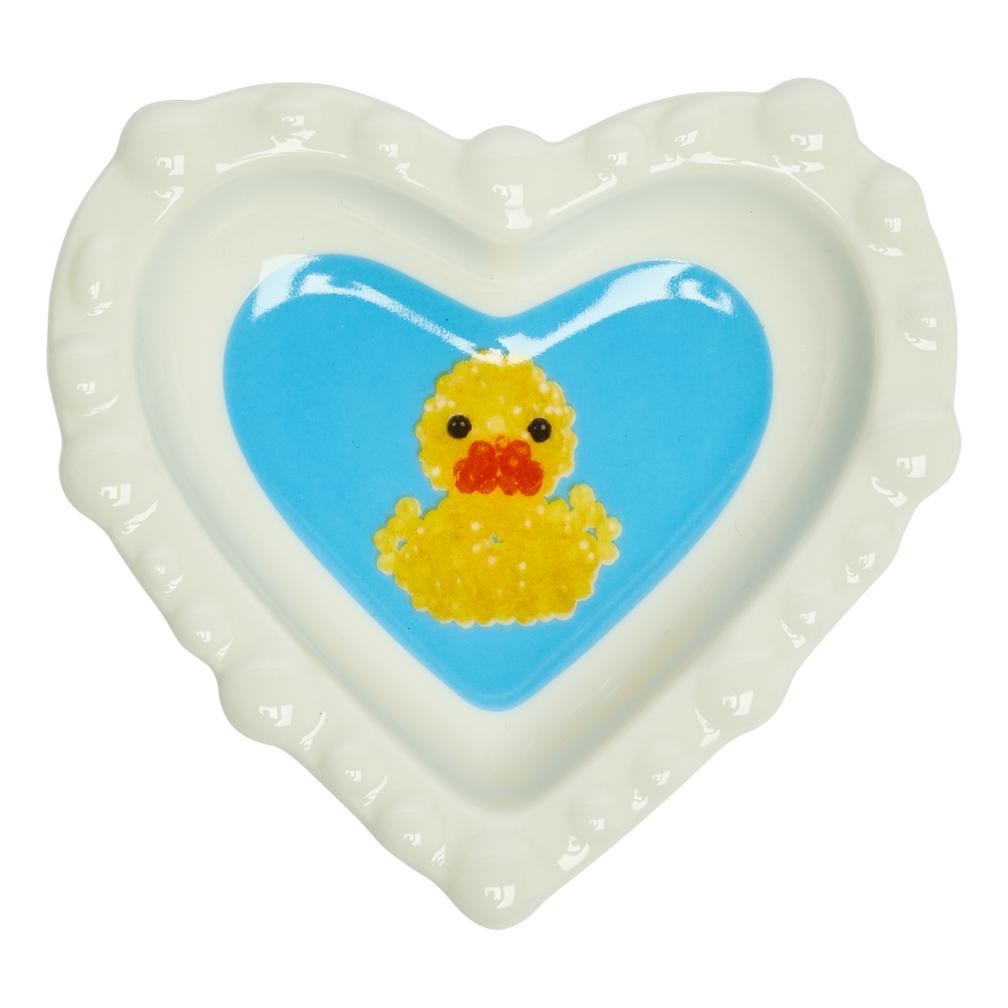 Heart-shaped dish with a yellow rubber duck on a blue background
