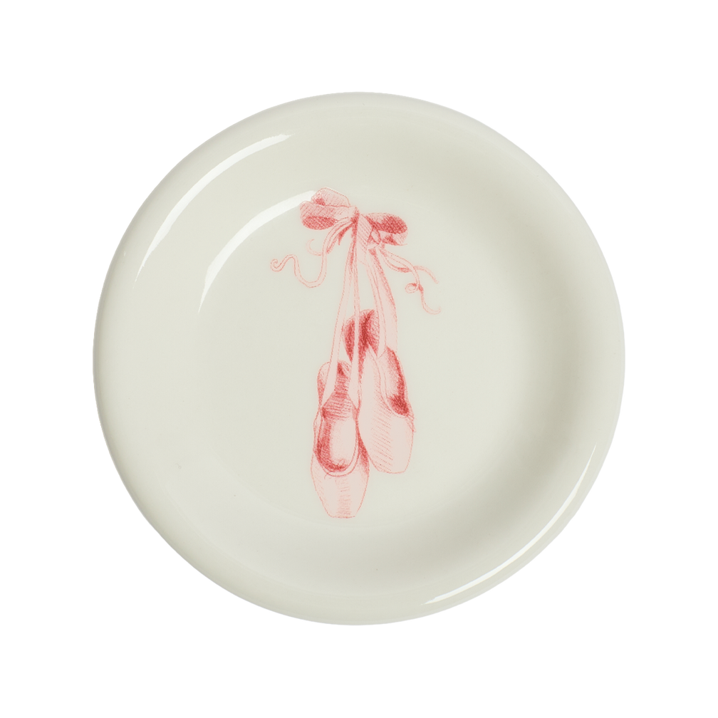 Round ceramic plate with pink ballet slipper design on a white background