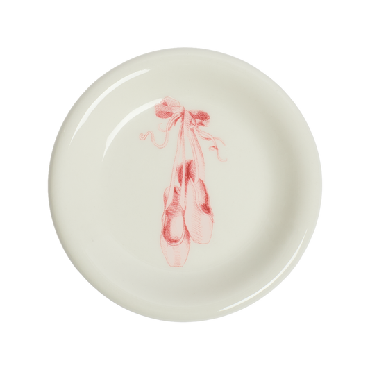 Round ceramic plate with pink ballet slipper design on a white background