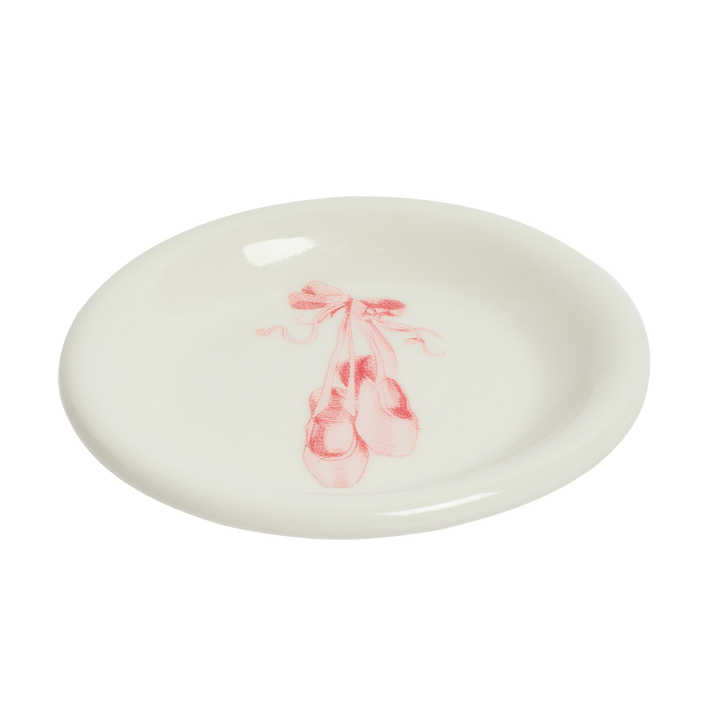 Round ceramic plate with pink ballet shoes design on a white background
