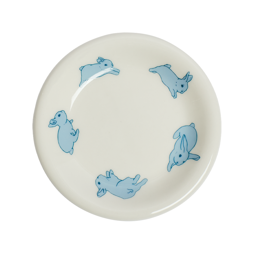 White plate with blue rabbit illustrations on a white background