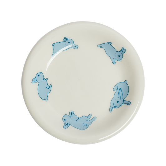 White plate with blue rabbit illustrations on a white background