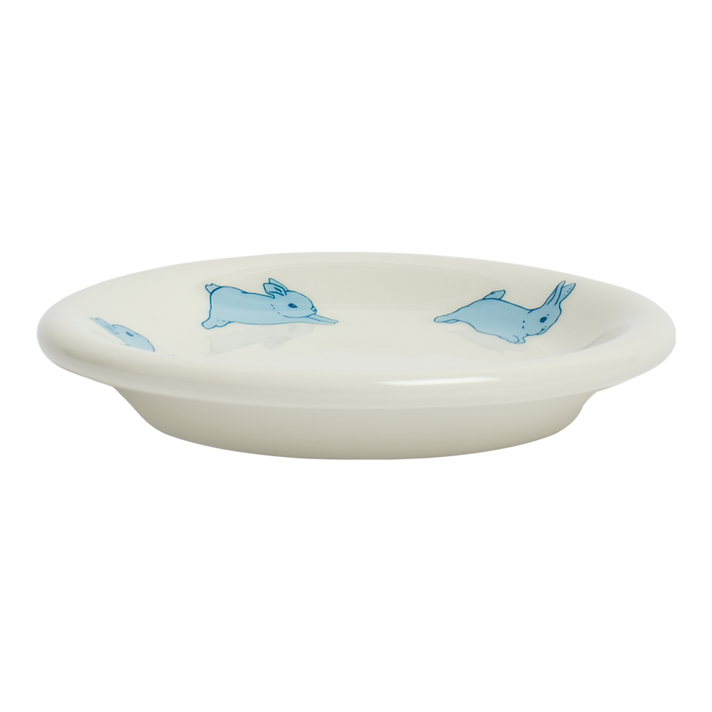 White ceramic dish with blue rabbit illustrations on a white background