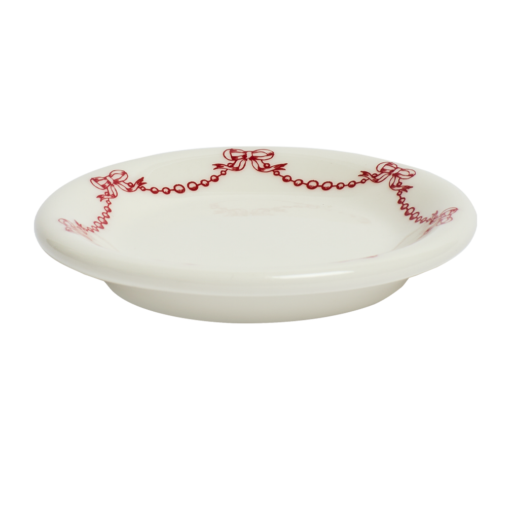 White ceramic plate with red decorative patterns on a white background