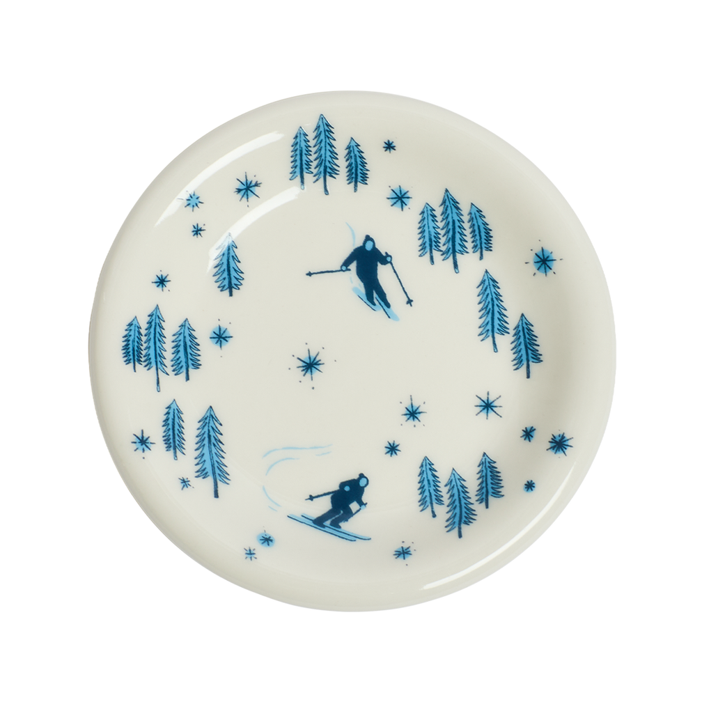 White plate with blue skiing and tree pattern on a white background