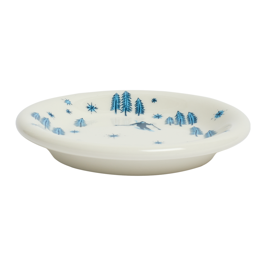 White ceramic plate with blue tree and star pattern on a white background