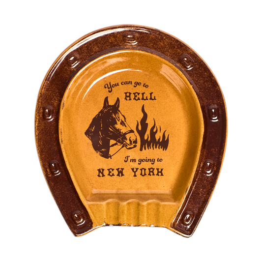 Horseshoe-shaped ceramic coaster with humorous text and horse illustration on a white background
