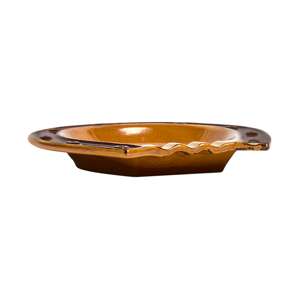 Brown ceramic dish with wavy edge on a white background
