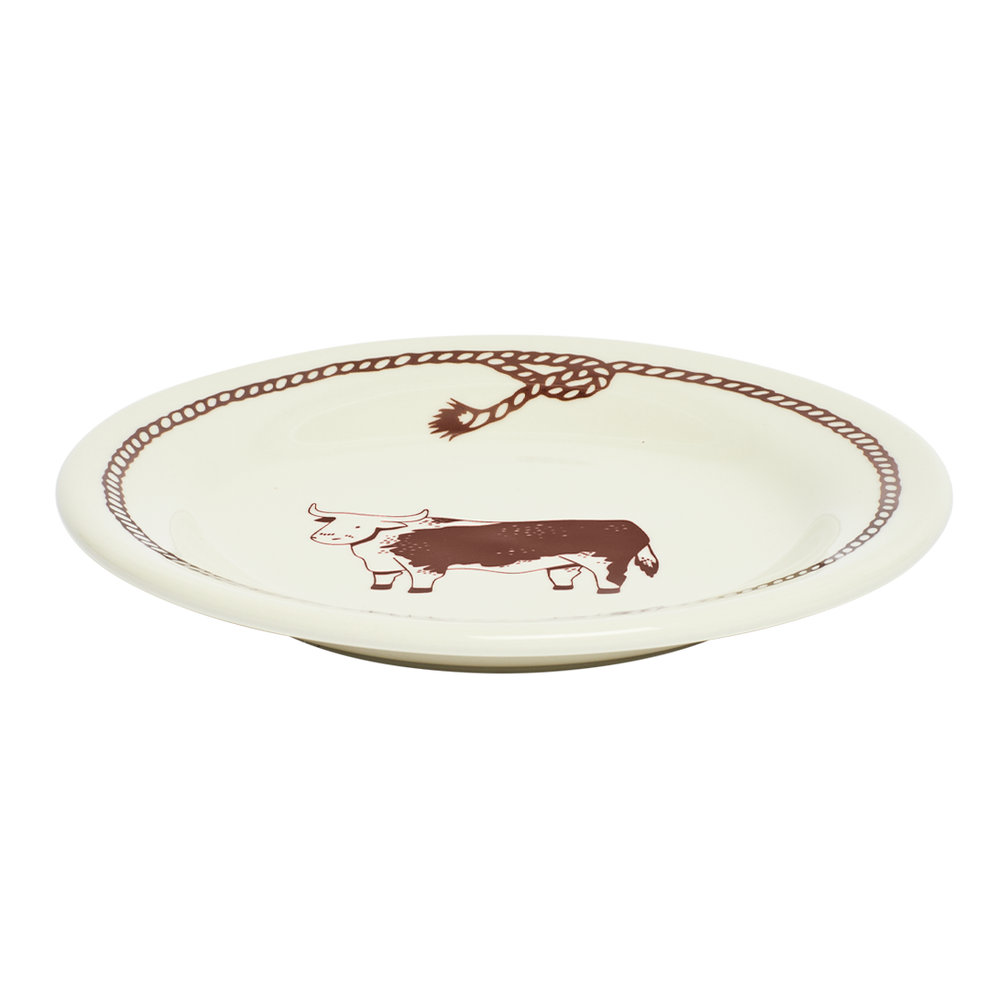 Round ceramic plate with a cow design on a white background