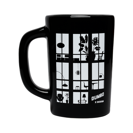 Black mug with white design featuring geometric shapes and 'Dumbo x Design' text on a white background