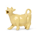 Butter yellow ceramic cow-shaped creamer with an open mouth spout and tail handle, side view