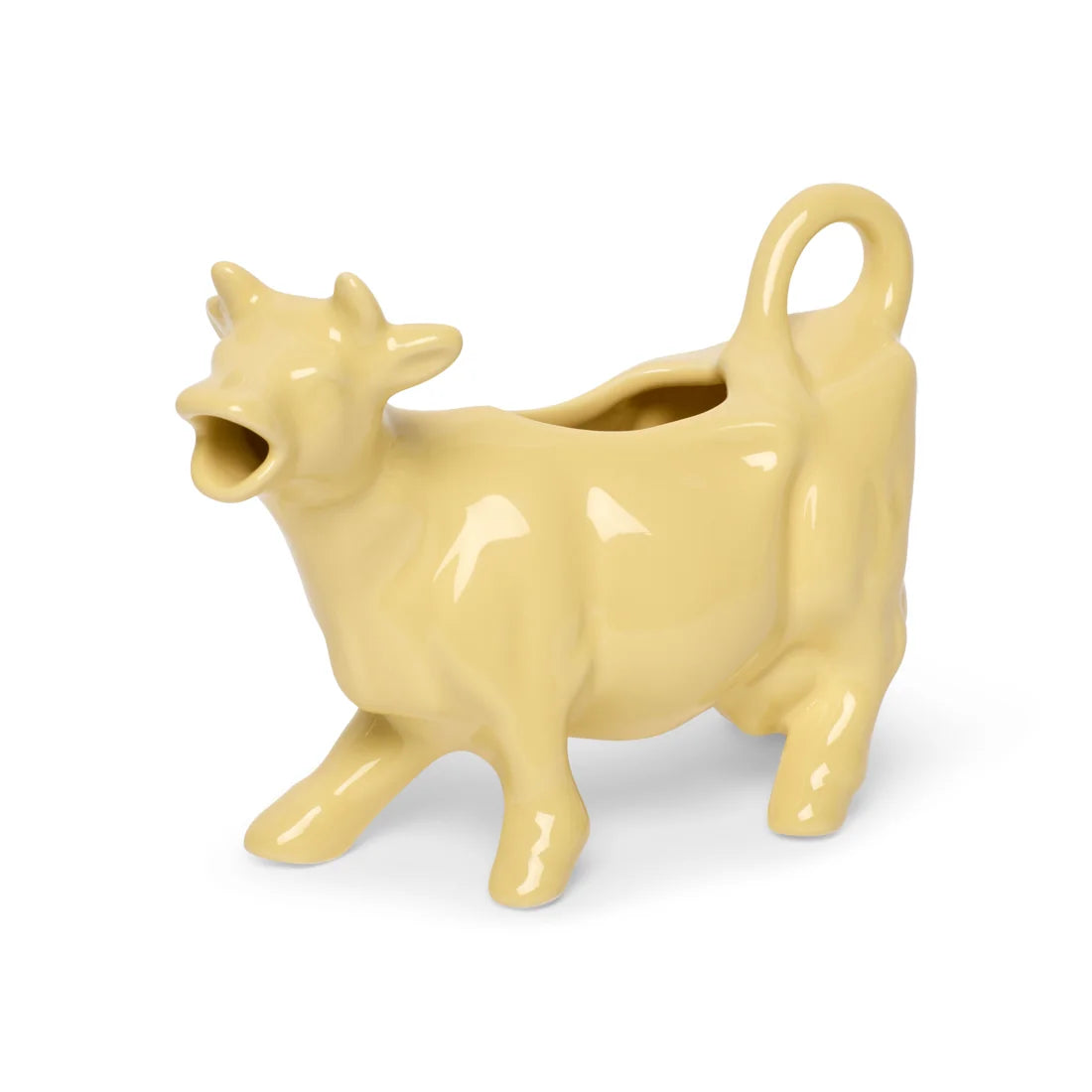 Yellow ceramic cow creamer at a slight angle showing the open back