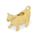 Yellow ceramic cow creamer from above showing the opening and curled tail handle