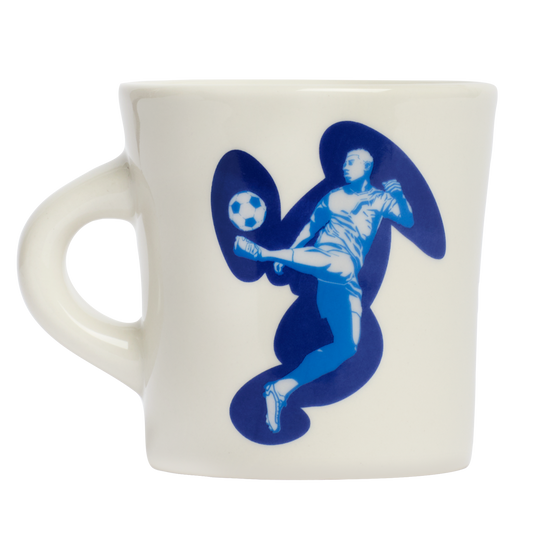 White ceramic mug with blue soccer player illustration and graphic swirl artwork, designed to add personality to everyday coffee routines and casual table settings