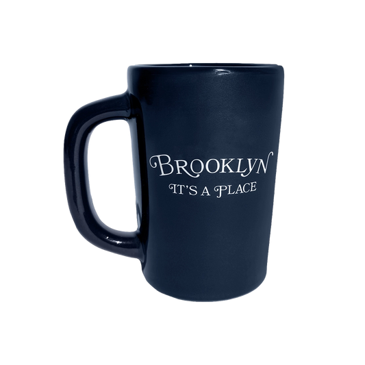 Navy blue Brooklyn It’s A Place ceramic mug featuring white Brooklyn lettering, a funny NYC coffee mug and gift for Brooklyn lovers.