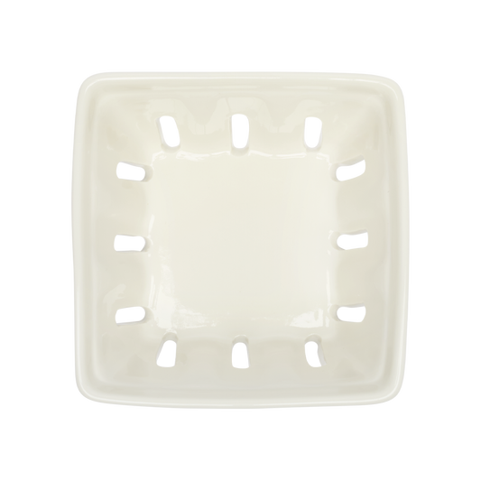 White ceramic basket with slotted design on a white background