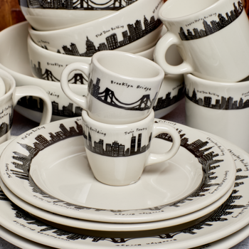 Set of ceramic dishes with skyline design on a wooden surface