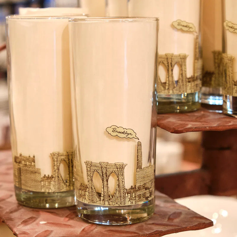 Two Brooklyn highball glasses with a gold Brooklyn Bridge skyline on a wooden tray