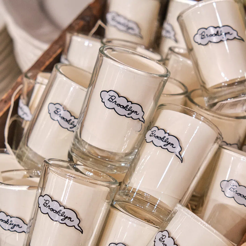 Pile of Brooklyn shot glasses with a black-outlined speech bubble in a display