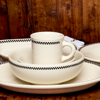 White ceramic tableware set with checkered pattern on a wooden surface