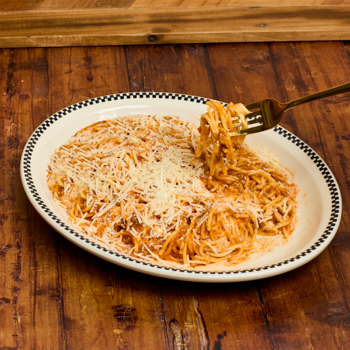 Spaghetti dish with a fork on a wooden table