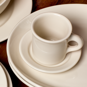 White ceramic cup and saucer on a wooden surface