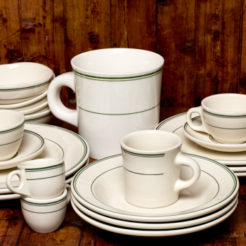 Set of white ceramic dinnerware with green stripes on a wooden surface